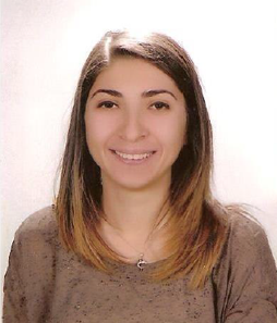 Aslihan Vuruskan smiles in portrait wearing a brown shirt and silver necklace