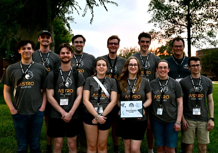 Ten Michigan Tech Astro-Huskies members stand together with a certificate and matching Astro-Huskies shirt.