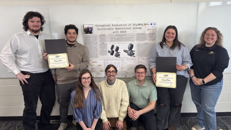 The Michigan Tech systems engineering capstone team poses with their research poster and certificates at the 2026 MTU Design Expo.