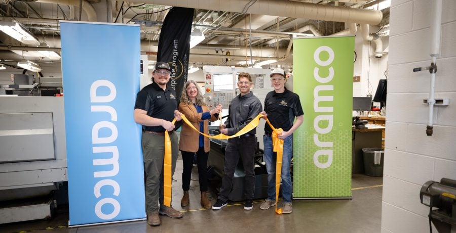 Dr. Marika Seigel and Aramco’s Andrew Baur cut a yellow ribbon with Michigan Tech students in the MMET Machine Shop