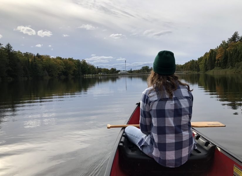 A student on a canoe in Ford Lake