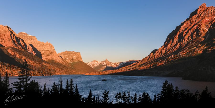 A small, lone island in the middle of a lake between mountains