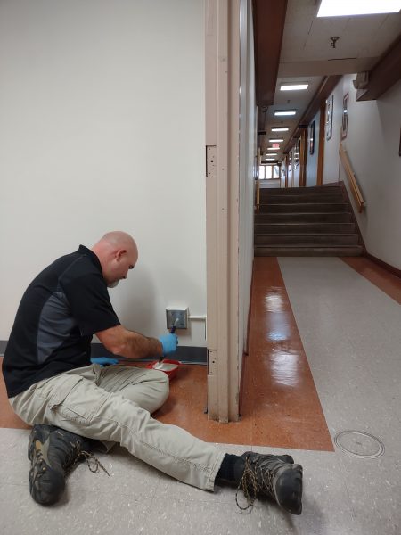 A custodian painting a wall