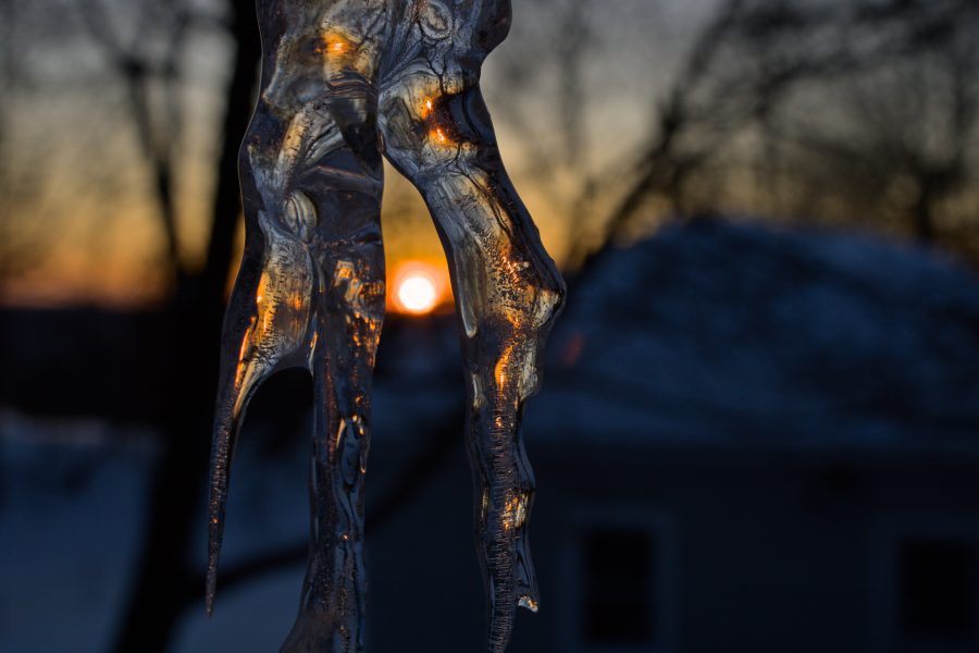 An icicle with an out of focus sunset in the background