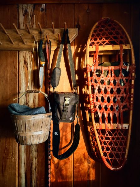Snowshoeing and outdoors equipment on a wooden wall