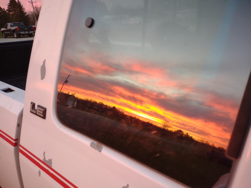 A sunrise reflected in a truck window