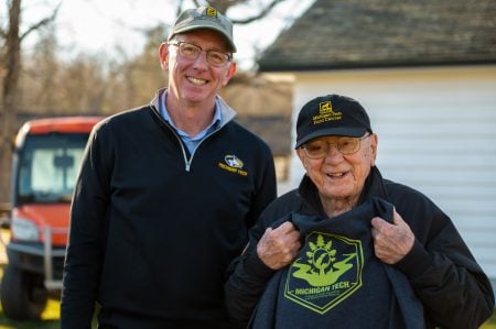 Steve Danis holding a CFRES sweatshirt, standing next to David Flaspohler.