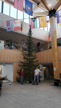  Four forestry club members stand inside the U. J. Noblet Forest Resources Building Atrium next to the holiday tree. 