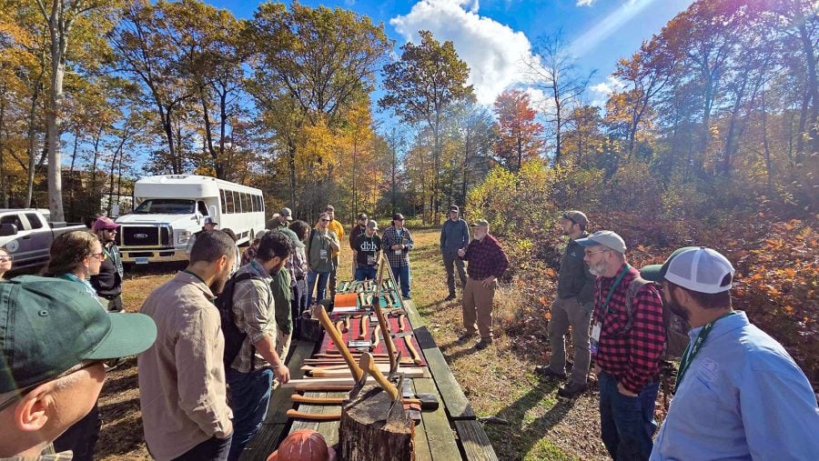 More than 25 foresters and SAF members from around the country gather outside for a workshop on types of wood-cutting axes during the SAF National Convention.