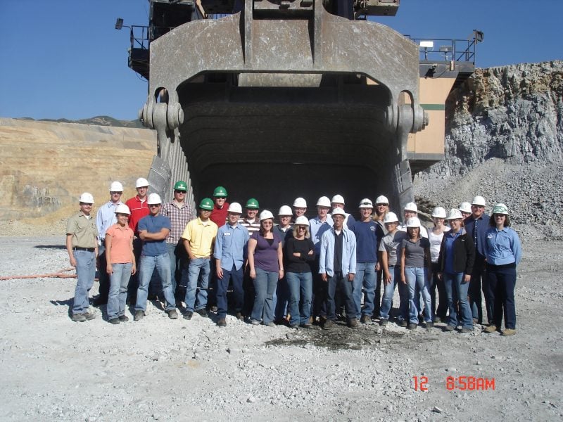 Walt stands in the back row of a group photo featuring the shovel dipper interns at Kennecott Utah Copper, surrounded by his colleagues and set against an industrial backdrop.