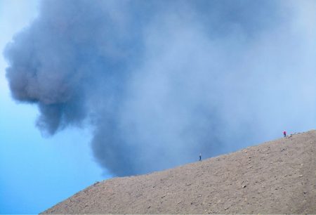 Simone and Federica Lanza, an MTU GMES alumn, working together to deploy and collect infrasound volcanic measurements during an active Strombolian volcanic eruption, with the glowing eruption in the background.