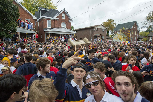 Drunken students at a loud street party during Queen's homecoming. This problem was addressed by Dr. Adam Wellstead's public policy innovation lab.
