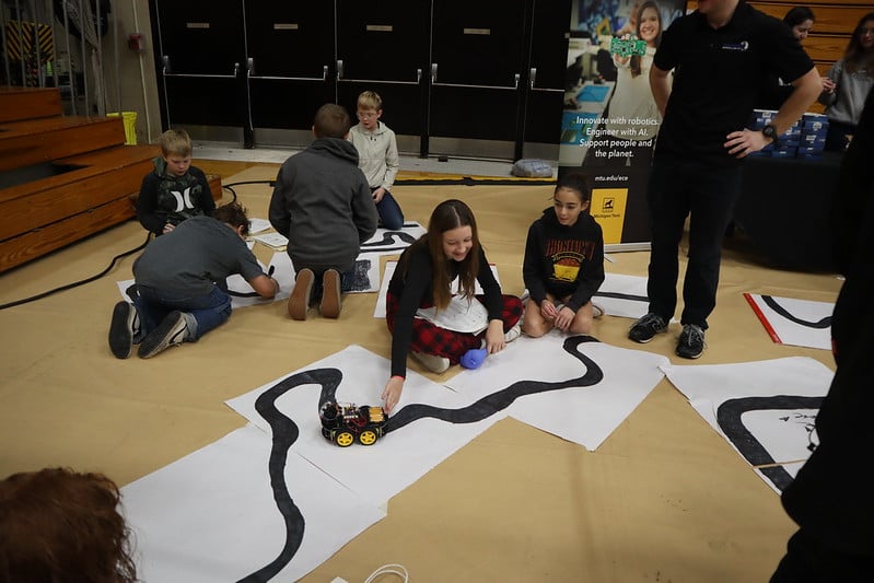 Students create their own tracks for EVs at MTU's table at the Copper Trails STEM event.