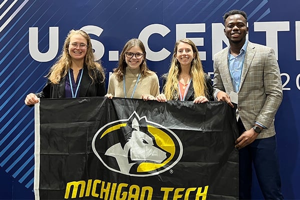 Michigan Tech students holding banner in front of the US Center pavilion