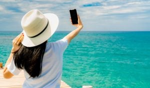 Young Asian woman wear straw hat in casual style use smartphone taking selfie 