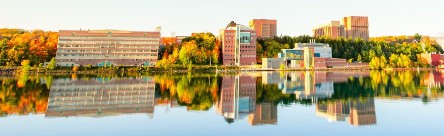 View of campus from across the Portage Canal with buildings reflecting off the water.