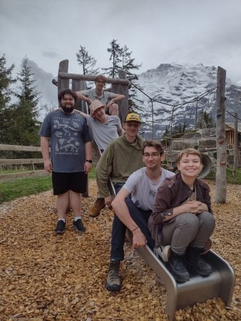 Students at a playground with mountain peaks in background