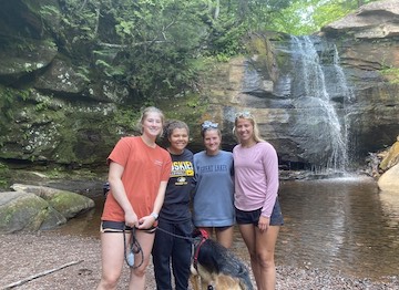 Riley with three friends standing in front of a waterfall