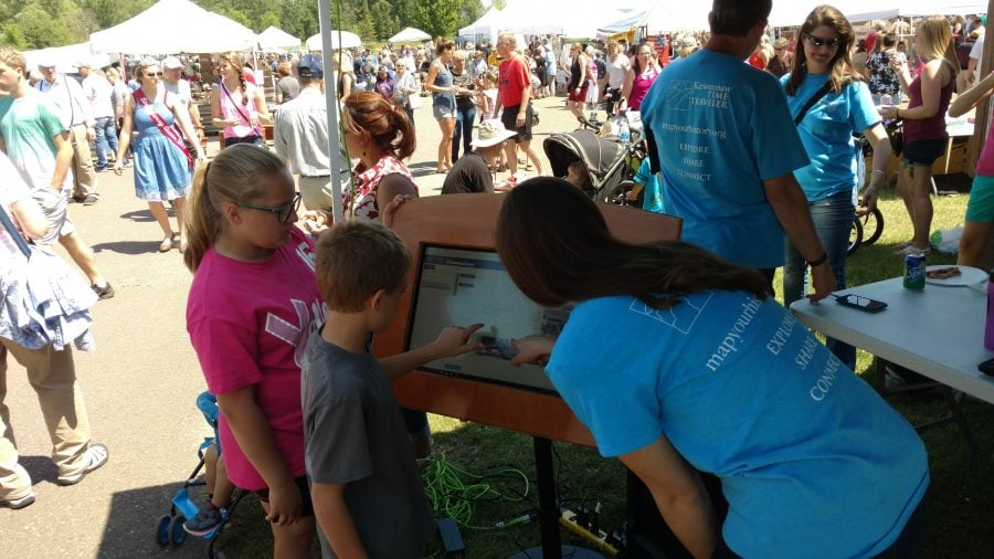 Two children viewing the time traveler demo with an researcher