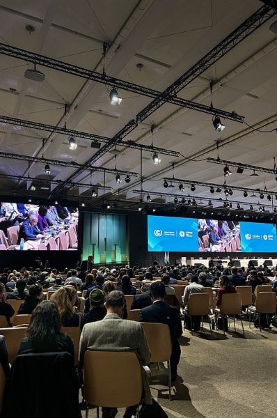 A few hundred attendees attend an indoor panel discussion at COP29.