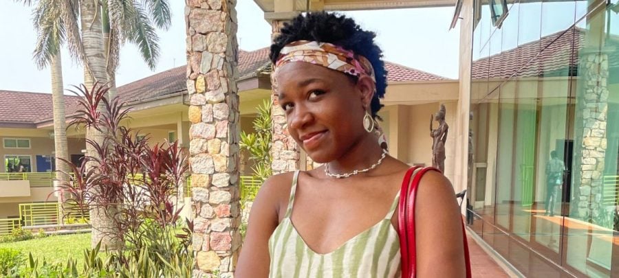 Nyasha stands outside on a sunny patio at Ashesi University in Ghana.