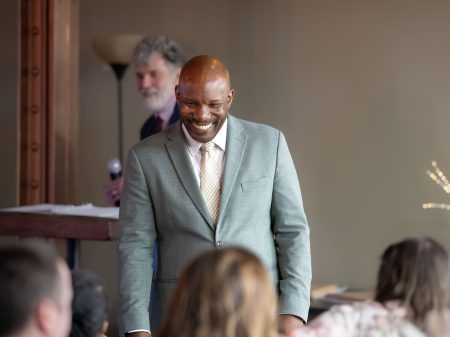 Derhun Sanders talks with faculty, staff, and guests after accepting his induction into the Academy of Sciences and Arts at an intimate ceremony.