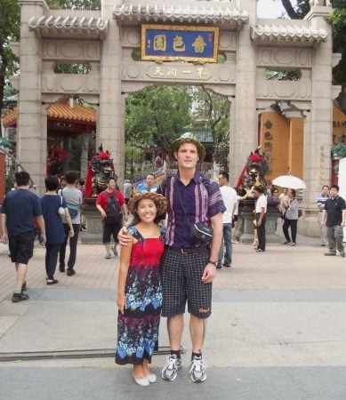Adam Tanielian looking at a Mickey Mouse plushie on his left shoulder.