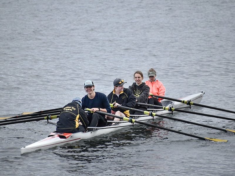 Aili Toyli and four other rowing club members practice in their boat on the waters of the Portage Canal.