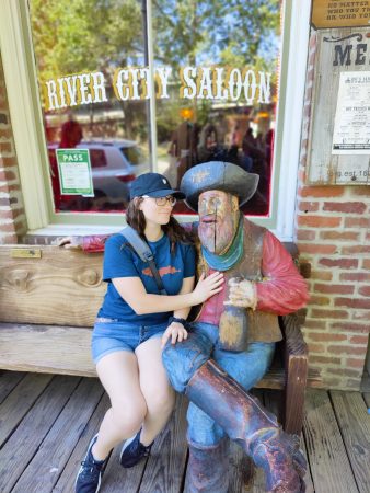 Student sits next to statue of gold prospector