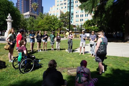 Students gathered around the instructor at a park
