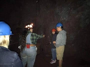 Larissa pointing out features to tourists underground in the mine