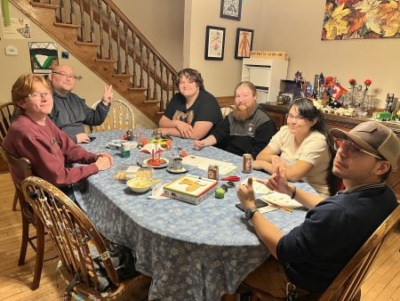 a group of students enjoying a meal at a faculty members house. 