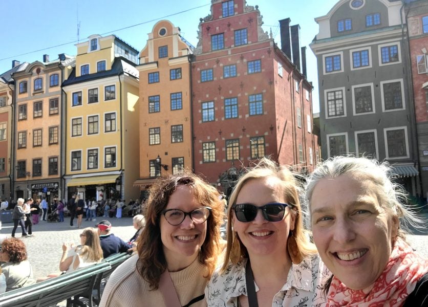 Lisa, Tara, and Molly in front of the historic buildings of Gamla Stan.