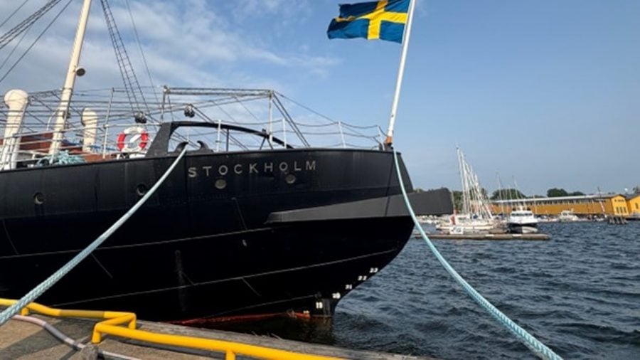 Aft of the SS Sankt Erik boat with the Swedish flag flying next to the pier