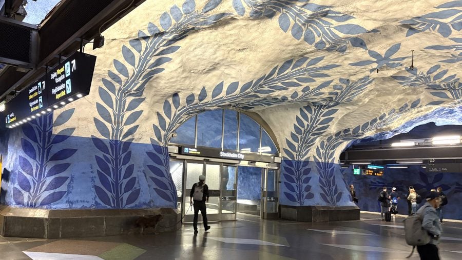 View of underground subway with painted flowers on the walls and ceilings in blue and white.