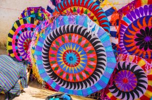 Colorful handmade kites for sale on the street. Locals display huge circular kites called barriletes & fly smaller ones each year in the cemetery on All Saints' Day to honor spirits of the dead.