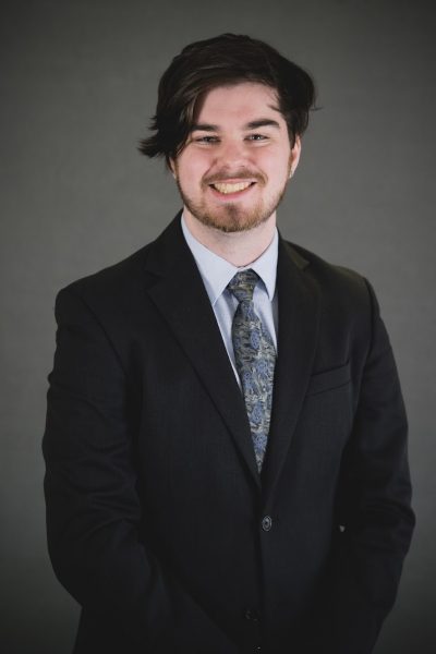 Sam Kalkman smiling in professional photo.
