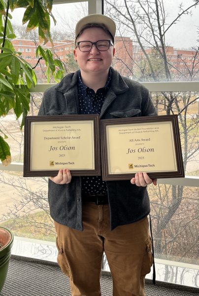 Jos Olson big smile while holding 2 department awards.