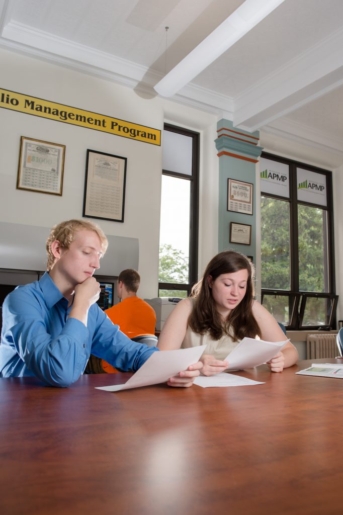 Two students sitting at a conference table studying.